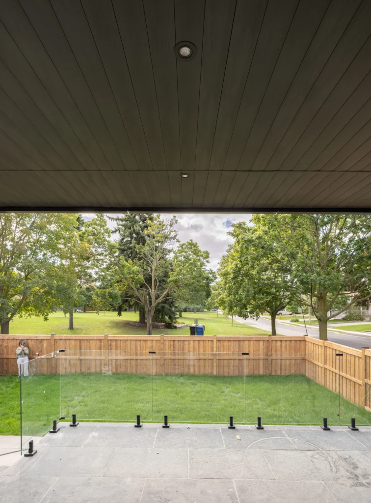Interior view of black aluminum soffit ceiling combined with gray wood-plastic composite panels and modern recessed lighting in North York home